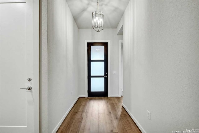 doorway featuring hardwood / wood-style floors and an inviting chandelier