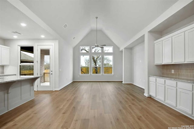 unfurnished dining area featuring vaulted ceiling, light hardwood / wood-style floors, and ceiling fan