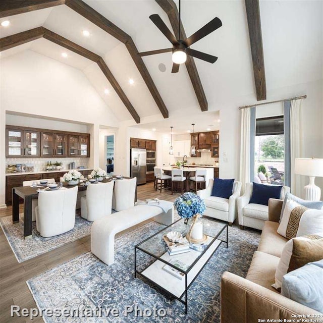 living room featuring high vaulted ceiling, beamed ceiling, ceiling fan, and dark wood-type flooring