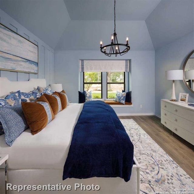 bedroom featuring wood-type flooring, a notable chandelier, and lofted ceiling