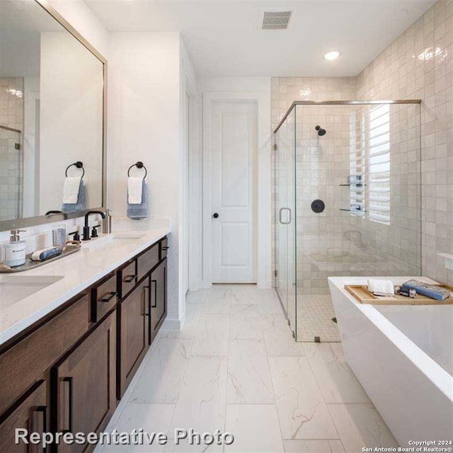 bathroom with vanity and independent shower and bath