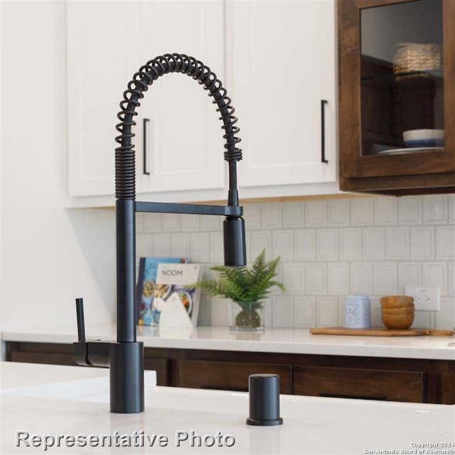 details featuring white cabinets and decorative backsplash