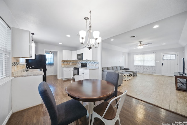 dining room featuring ceiling fan with notable chandelier, sink, and dark hardwood / wood-style flooring