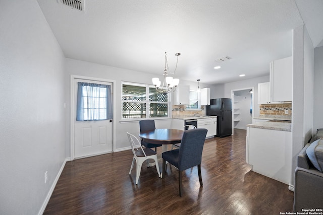 dining room with dark wood-type flooring and a notable chandelier