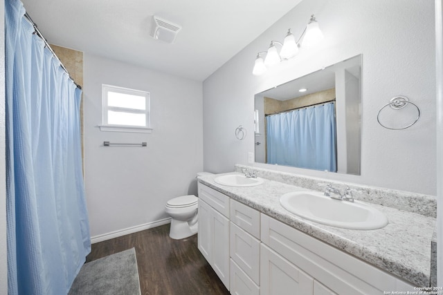 bathroom featuring curtained shower, hardwood / wood-style floors, vanity, and toilet