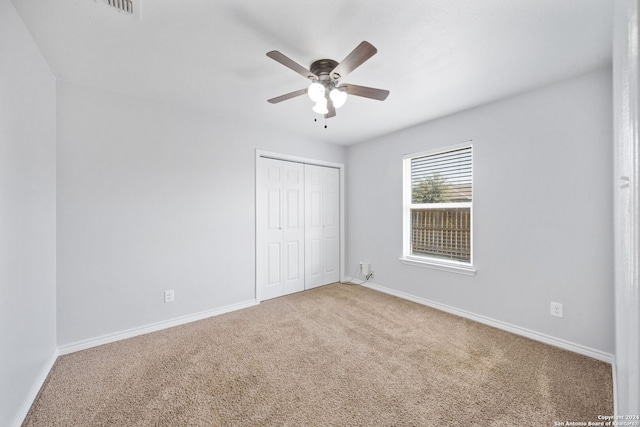 unfurnished bedroom with ceiling fan, carpet floors, and a closet