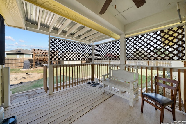 wooden terrace featuring ceiling fan and a lawn