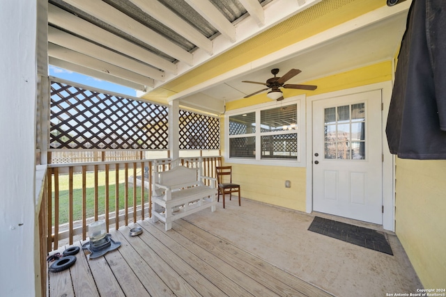 deck featuring ceiling fan and a lawn