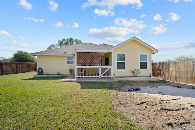 rear view of house featuring a yard and a patio