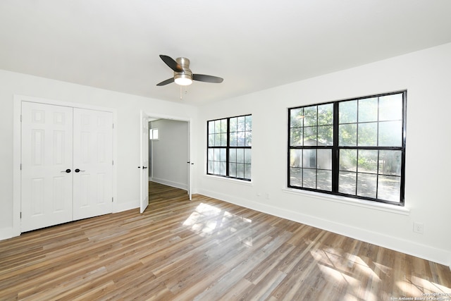 unfurnished bedroom featuring a closet, ceiling fan, and light wood-type flooring