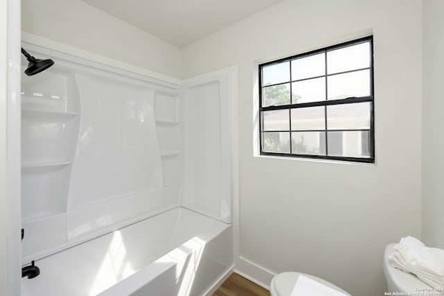 bathroom with toilet, shower / tub combination, and hardwood / wood-style flooring