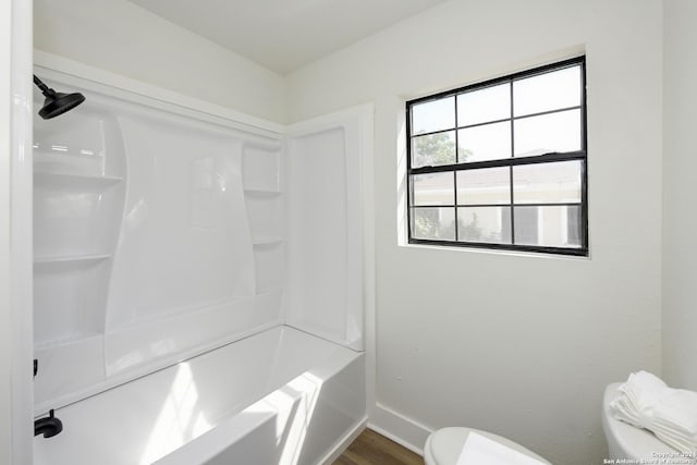 full bathroom featuring baseboards, wood finished floors, and toilet