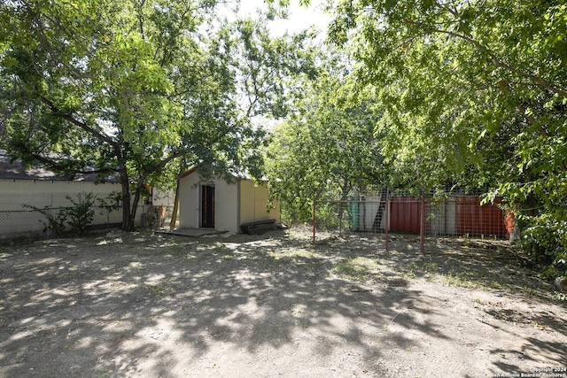 view of yard featuring fence, a storage shed, and an outdoor structure