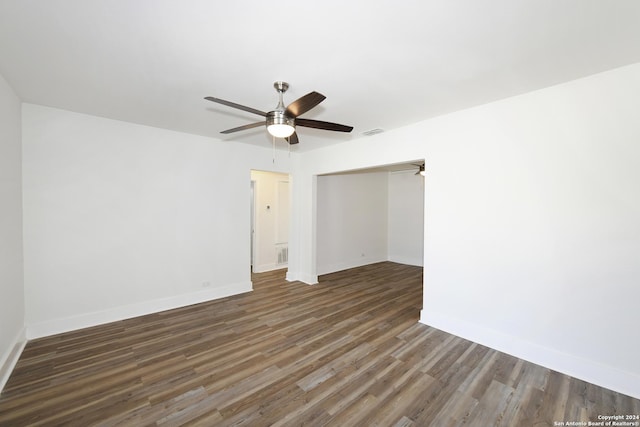 empty room with baseboards, visible vents, wood finished floors, and a ceiling fan