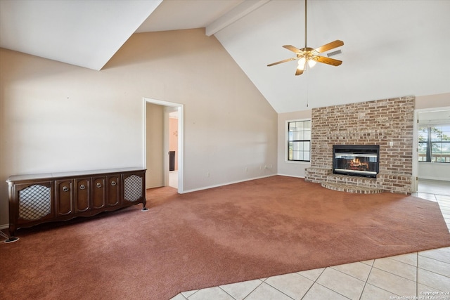 unfurnished living room featuring a fireplace, high vaulted ceiling, light colored carpet, and a healthy amount of sunlight