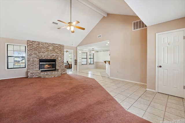 unfurnished living room featuring ceiling fan, beamed ceiling, light tile patterned floors, a brick fireplace, and high vaulted ceiling