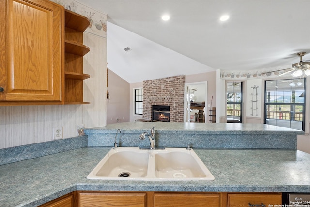 kitchen with a fireplace, lofted ceiling, sink, and ceiling fan