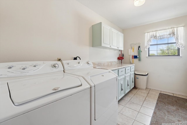 laundry room with light tile patterned floors, cabinets, and independent washer and dryer