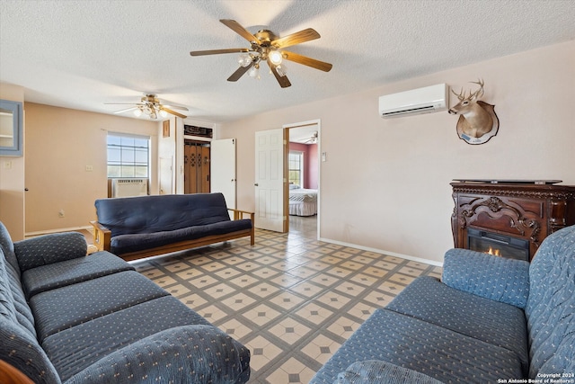 living room featuring a wall unit AC, ceiling fan, tile patterned flooring, cooling unit, and a textured ceiling