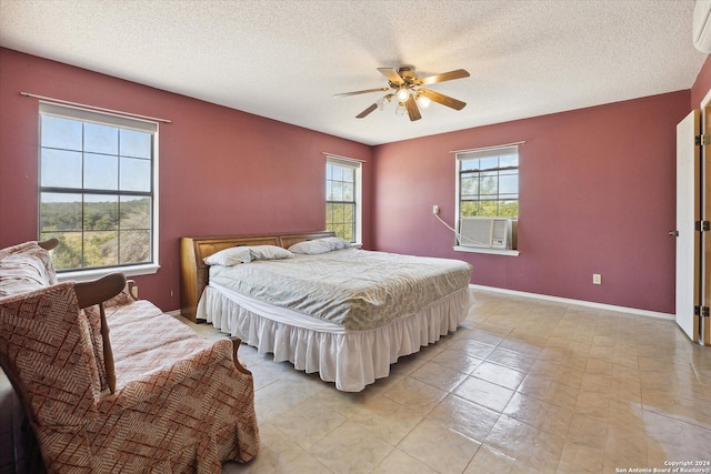 bedroom featuring a wall mounted air conditioner, a textured ceiling, and ceiling fan