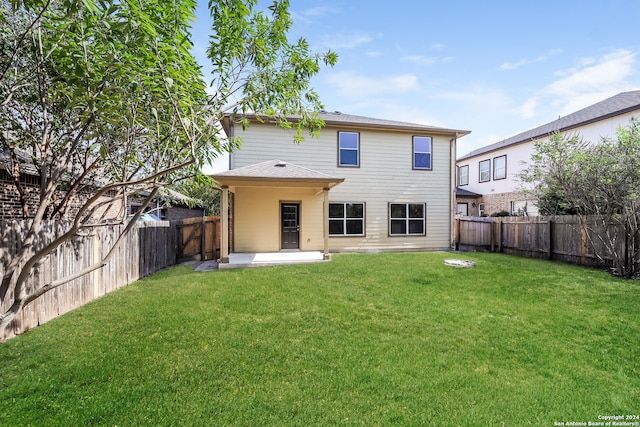 rear view of property with a yard and a patio area