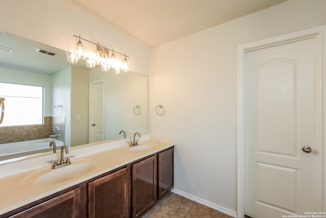 bathroom with tile patterned flooring, a tub, and vanity