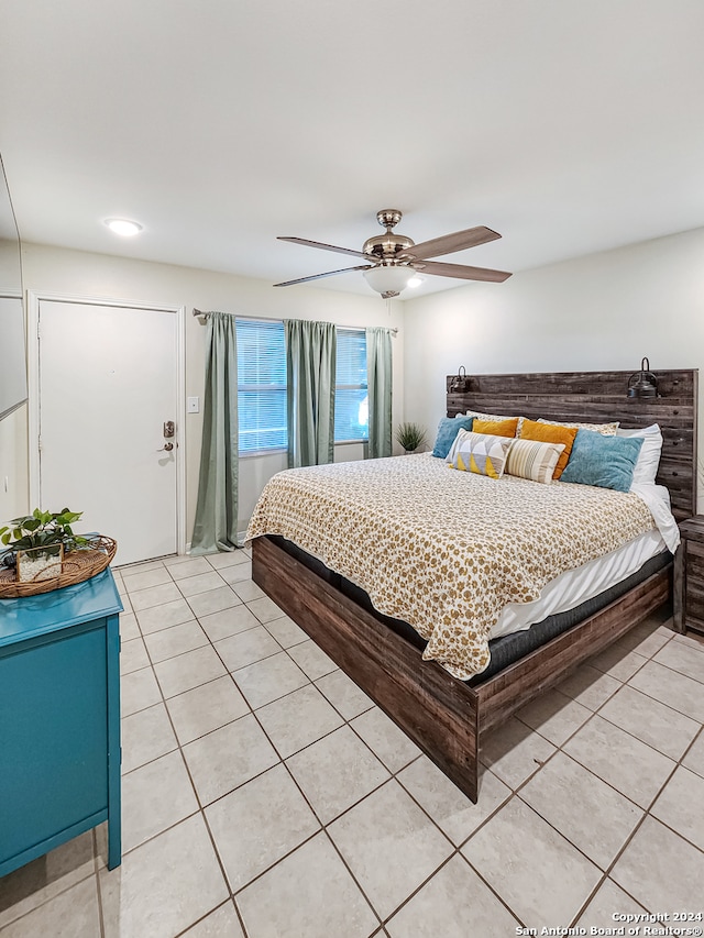 tiled bedroom featuring ceiling fan