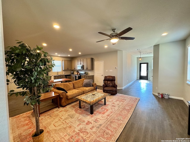 living room featuring light wood-type flooring, ceiling fan, and sink