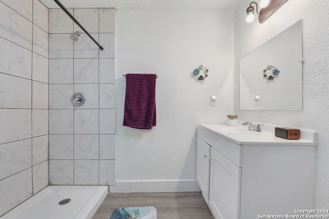 bathroom featuring vanity, tiled shower, and hardwood / wood-style flooring