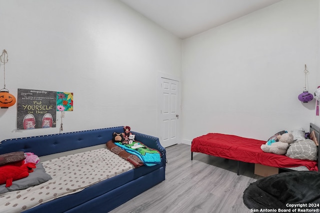 bedroom with wood-type flooring and vaulted ceiling