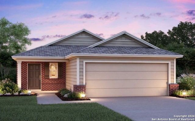 view of front of property with a garage and a yard