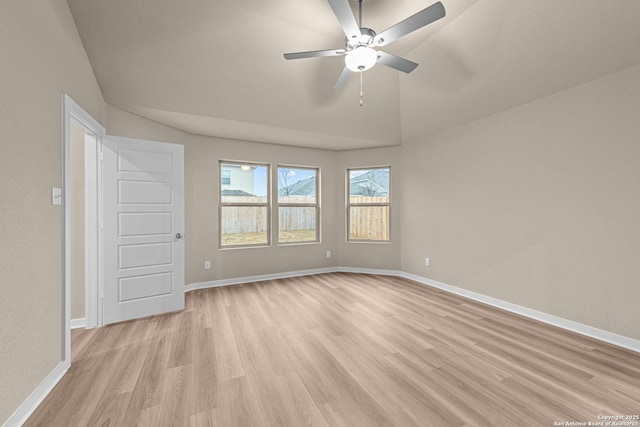 spare room featuring ceiling fan, lofted ceiling, and light wood-type flooring