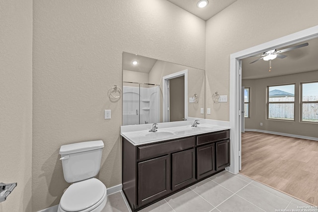 bathroom with toilet, an enclosed shower, vanity, ceiling fan, and tile patterned flooring