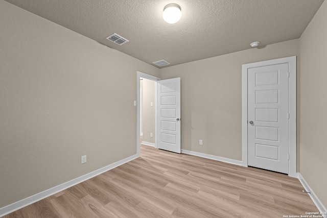 unfurnished bedroom featuring a textured ceiling and light wood-type flooring