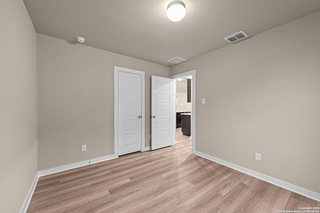 unfurnished bedroom featuring light hardwood / wood-style flooring and a textured ceiling