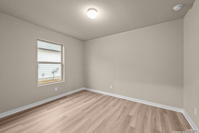 spare room featuring light hardwood / wood-style flooring and a textured ceiling