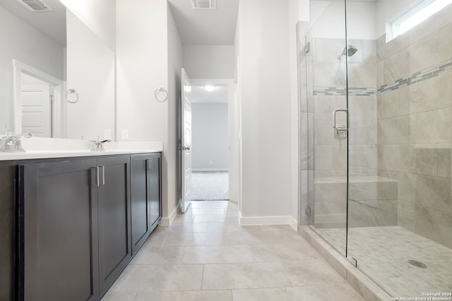 bathroom featuring vanity, a shower with shower door, and tile patterned flooring