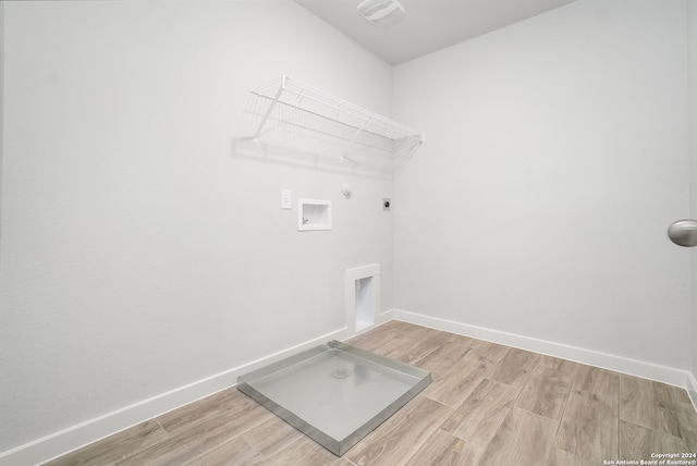 washroom featuring washer hookup, light hardwood / wood-style flooring, hookup for a gas dryer, and electric dryer hookup