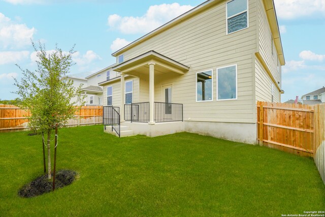 rear view of property featuring a yard