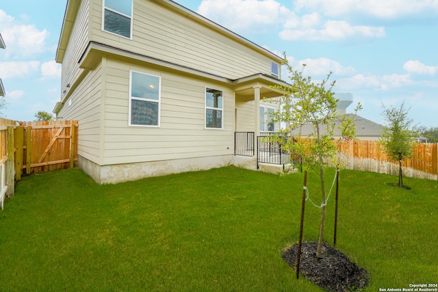 back of house featuring a lawn