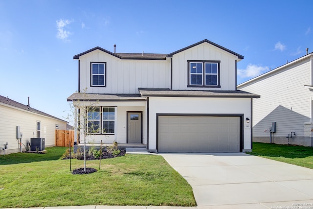 view of front of house with a front lawn, cooling unit, and a garage