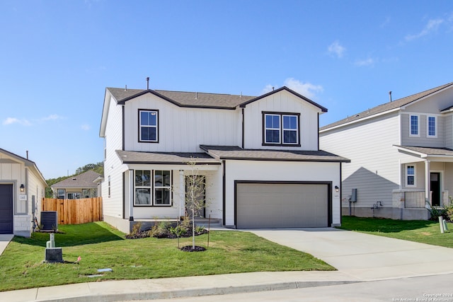 view of front of house with a front yard, a garage, and central AC unit