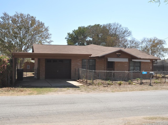 105 S Sayers Dr, Devine, TX 78016 - ranch-style home featuring a garage, brick siding, driveway, and a carport