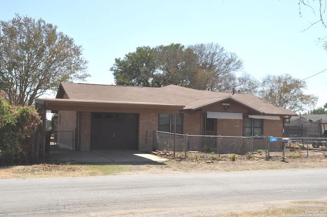 105 S Sayers Dr, Devine, TX 78016 - ranch-style home with a garage, brick siding, a fenced front yard, and driveway