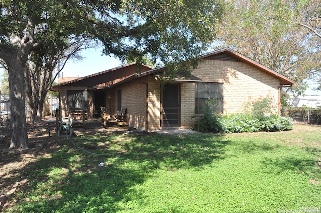 rear view of property featuring a yard