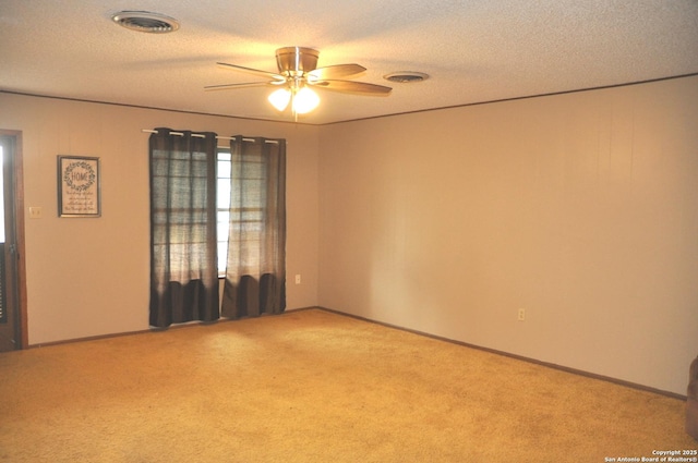 105 S Sayers Dr, Devine, TX 78016 - spare room with ceiling fan, light carpet, a textured ceiling, and baseboards