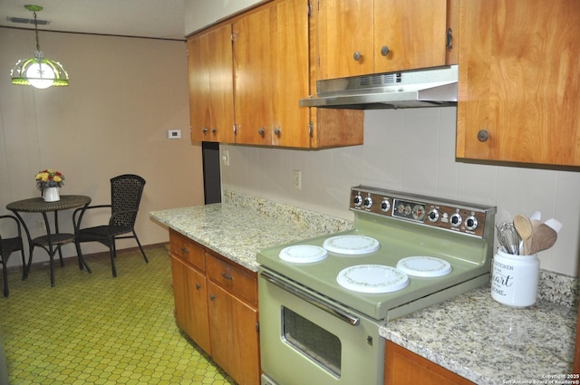 105 S Sayers Dr, Devine, TX 78016 - kitchen with under cabinet range hood, electric range, brown cabinets, and backsplash