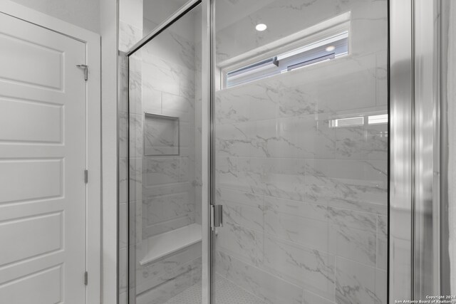 bathroom with a shower with door