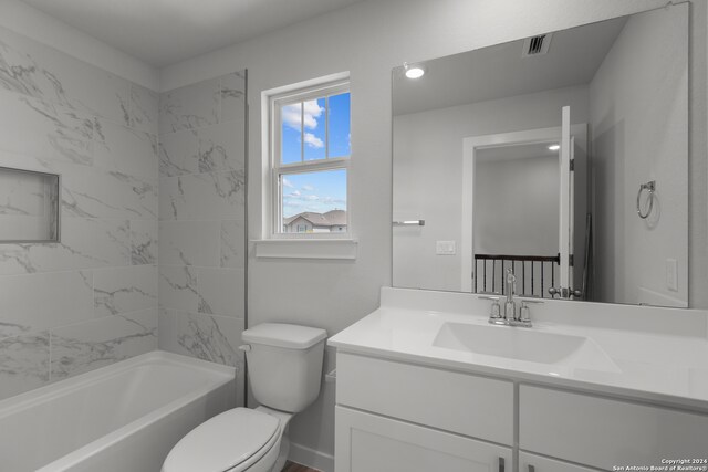 full bathroom featuring vanity, tiled shower / bath combo, and toilet