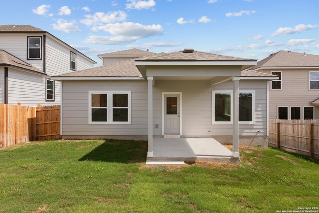 rear view of house featuring a yard and a patio area